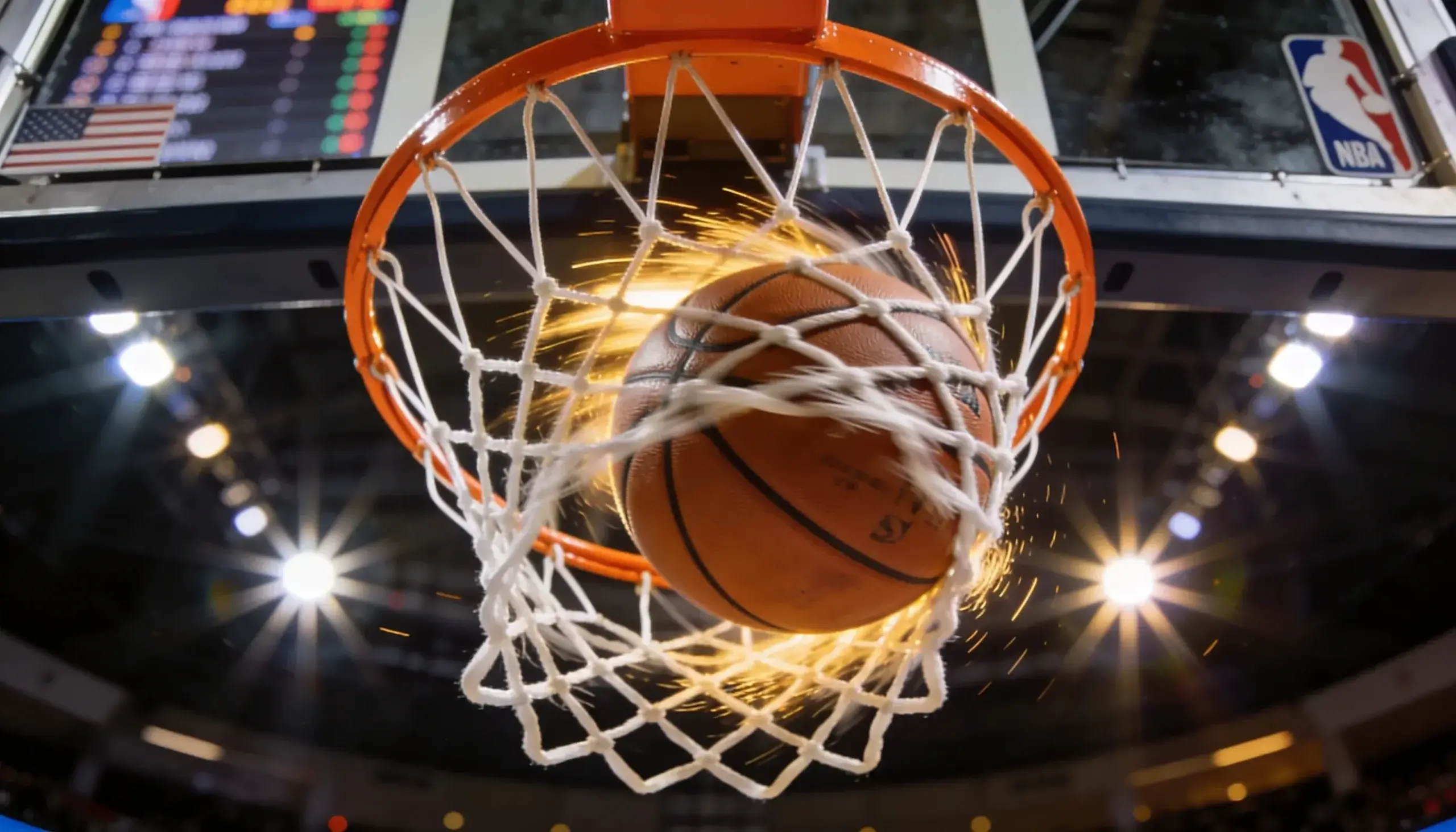 Basketball going through the hoop during an NBA game with the scoreboard visible in the background